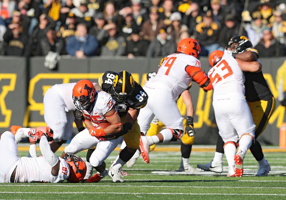 Iowa Hawkeyes defensive end A.J. Epenesa (94) brings down Illinois Fighting Illini running back Dre Brown (25) during the third quarter of their game at Kinnick Stadium in Iowa City on Saturday, Nov 23, 2019. (Stephen Mally/hawkeyesports.com)
