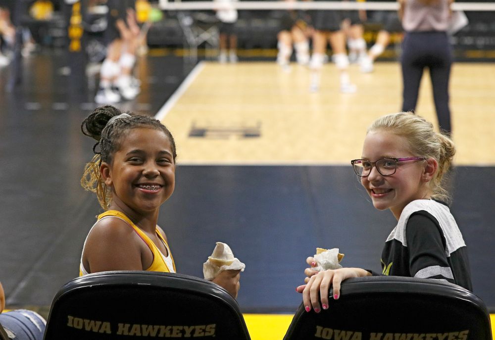 Two young fans eat ice cream cones before the Big Ten/Pac-12 Challenge match against Colorado at Carver-Hawkeye Arena in Iowa City on Friday, Sep 6, 2019. (Stephen Mally/hawkeyesports.com)