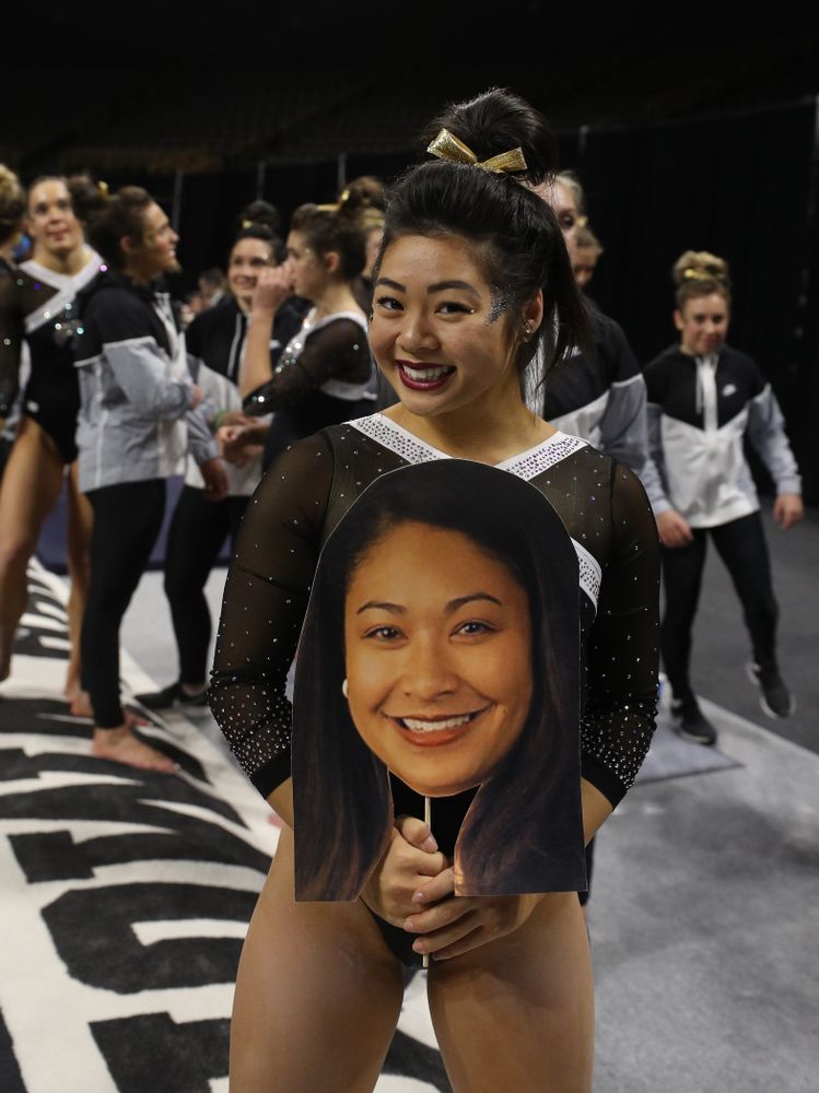 Iowa's Clair Kaji holds a photo of head coach Larissa Libby during their meet against the Rutgers Scarlet Knights Saturday, January 26, 2019 at Carver-Hawkeye Arena. (Brian Ray/hawkeyesports.com)