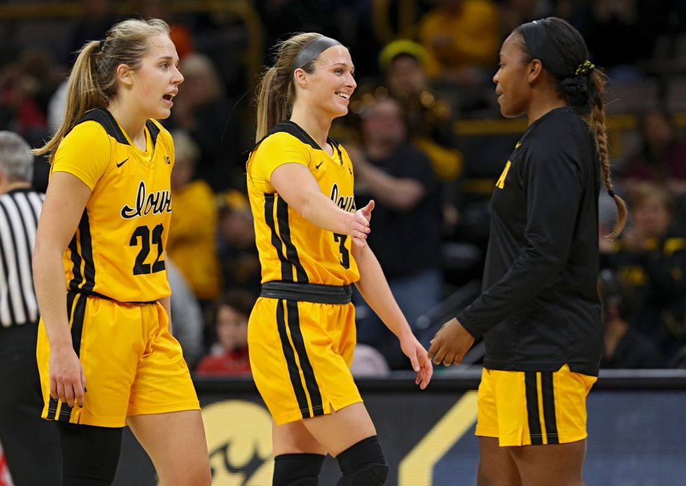 Iowa Hawkeyes guard Makenzie Meyer (3) gets a high-five from guard Zion Sanders (21) as she heads to the bench for a timeout with guard Kathleen Doyle (22) during the fourth quarter of their game at Carver-Hawkeye Arena in Iowa City on Thursday, January 23, 2020. (Stephen Mally/hawkeyesports.com)