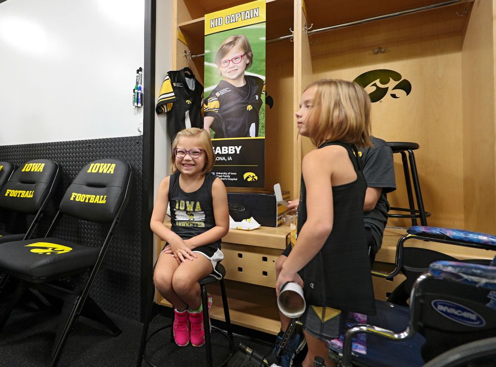 Kid Captain Gabby Yoder sits at her locker during Kids Day at Kinnick Stadium in Iowa City on Saturday, Aug 10, 2019. (Stephen Mally/hawkeyesports.com)