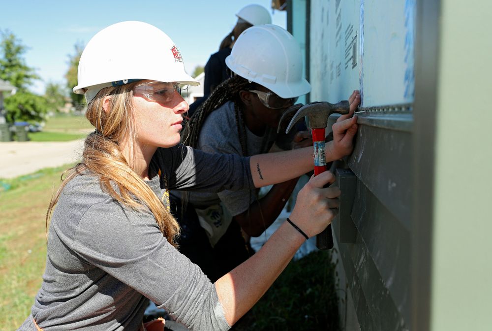 Iowa’s Kate Martin hammers in a nail on a piece of siding as they work on a Habitat for Humanity Women Build project in Iowa City on Wednesday, Sep 25, 2019. (Stephen Mally/hawkeyesports.com)