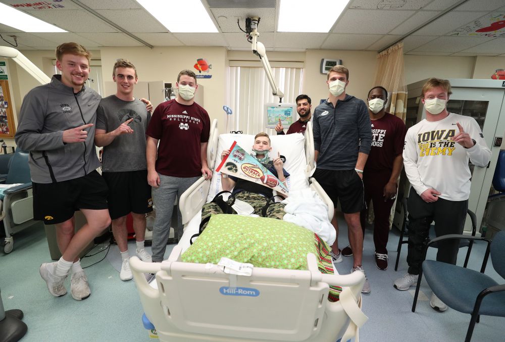 Iowa Hawkeyes quarterback Spencer Petras (7), punter Ryan Gersonde (2), and wide receiver Max Cooper (19) pose for photos with players from Mississippi State during a visit to Tampa General Hospital as part of the Outback Bowl Friday, December 28, 2018 in Tampa, FL.(Brian Ray/hawkeyesports.com)