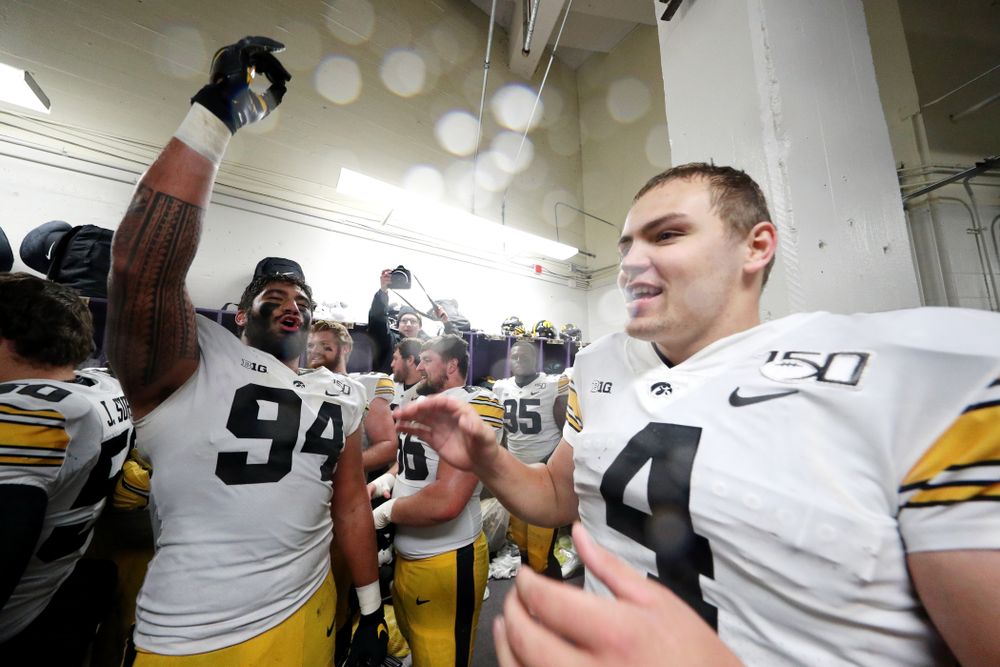 Iowa Hawkeyes defensive end A.J. Epenesa (94) and quarterback Nate Stanley (4) celebrate their victory against the Northwestern Wildcats Saturday, October 26, 2019 at Ryan Field in Evanston, Ill. (Brian Ray/hawkeyesports.com)