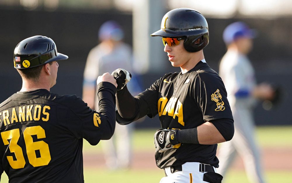 Iowa catcher Tyler Snep (16) gets a fist bump from volunteer assistant Jimmy Frankos after getting a hit during the fourth inning of their college baseball game at Duane Banks Field in Iowa City on Tuesday, March 10, 2020. (Stephen Mally/hawkeyesports.com)