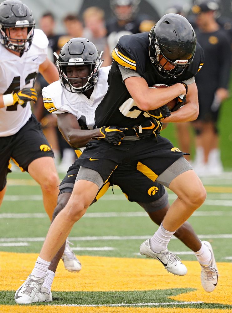 Iowa Hawkeyes wide receiver Jackson Ritter (29) is wrapped up by defensive back D.J. Johnson (12) during Fall Camp Practice No. 15 at the Hansen Football Performance Center in Iowa City on Monday, Aug 19, 2019. (Stephen Mally/hawkeyesports.com)