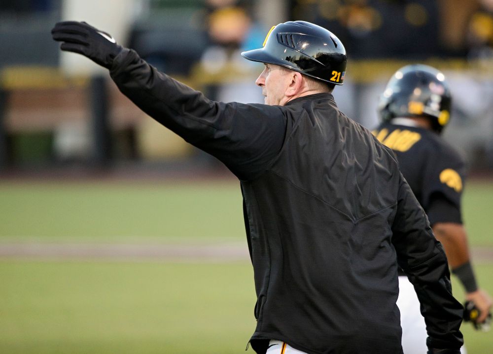 Iowa Hawkeyes head coach Rick Heller waves in runners during the fifth inning of their game at Duane Banks Field in Iowa City on Tuesday, March 3, 2020. (Stephen Mally/hawkeyesports.com)