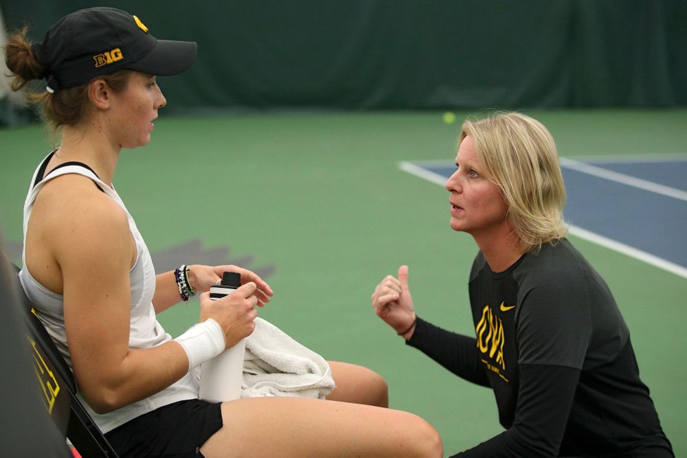 Iowa’s Elise Van Heuvelen (from left) talks with head coach Sasha Schmid during her singles match at the Hawkeye Tennis and Recreation Complex in Iowa City on Sunday, February 23, 2020. (Stephen Mally/hawkeyesports.com)