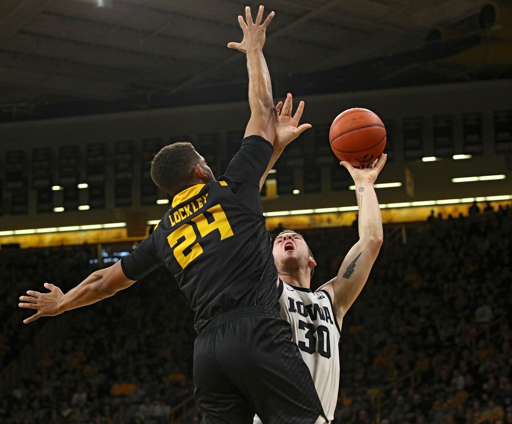 Iowa Hawkeyes guard Connor McCaffery (30) scores a basket around the arm of Kennesaw State Owls forward Bryson Lockley (24) during the first half of their their game at Carver-Hawkeye Arena in Iowa City on Sunday, December 29, 2019. (Stephen Mally/hawkeyesports.com)
