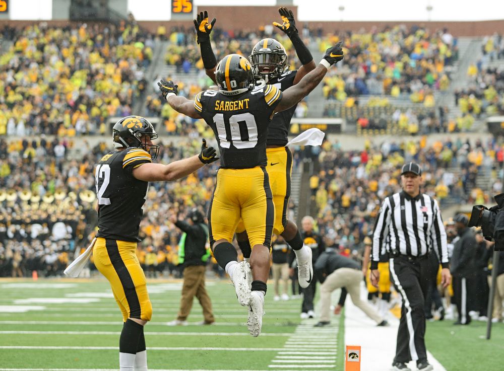 Iowa Hawkeyes running back Mekhi Sargent (10) celebrates his touchdown run with running back Tyler Goodson (15) and tight end Shaun Beyer (42) during the fourth quarter of their game at Kinnick Stadium in Iowa City on Saturday, Oct 19, 2019. (Stephen Mally/hawkeyesports.com)