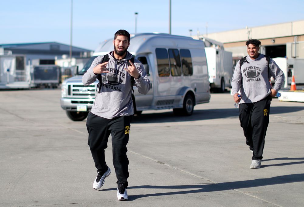Iowa Hawkeyes defensive end A.J. Epenesa (94) and offensive lineman Tristan Wirfs (74) board the team plane at the Eastern Iowa Airport Saturday, December 21, 2019 on the way to San Diego, CA for the Holiday Bowl. (Brian Ray/hawkeyesports.com)