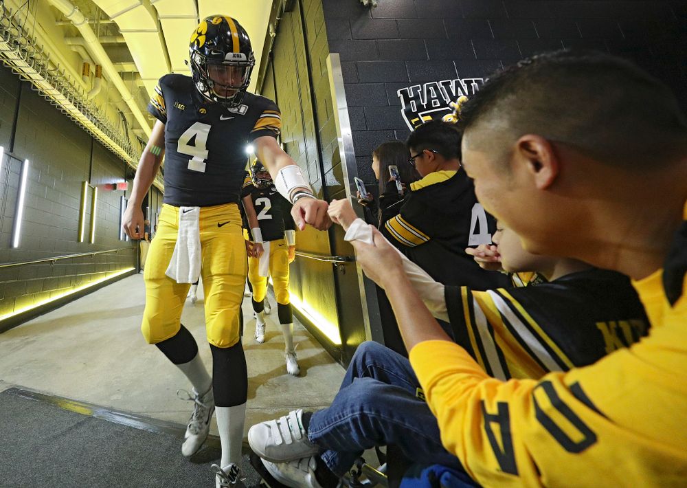 Iowa Hawkeyes quarterback Nate Stanley (4) gives Kid Captain Enzo Thongsoum a fist bump before their game at Kinnick Stadium in Iowa City on Saturday, Sep 28, 2019. (Stephen Mally/hawkeyesports.com)
