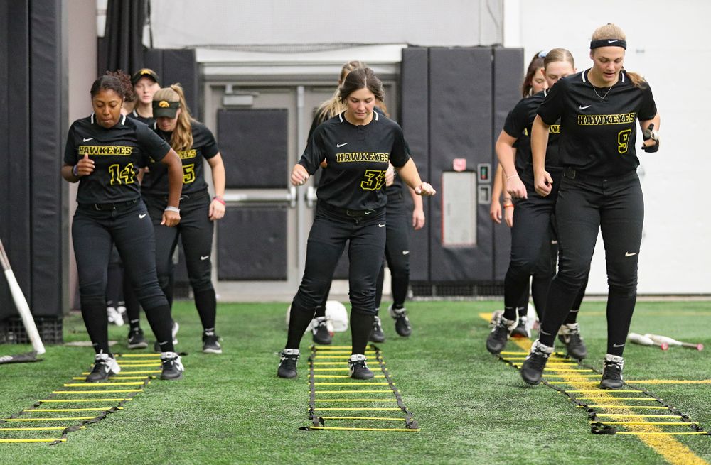 Iowa infielder Nia Carter (14), outfielder Riley Sheehy (33), and utility/catcher Abby Lien (9) run a drill during Iowa Softball Media Day at the Hawkeye Tennis and Recreation Complex in Iowa City on Thursday, January 30, 2020. (Stephen Mally/hawkeyesports.com)