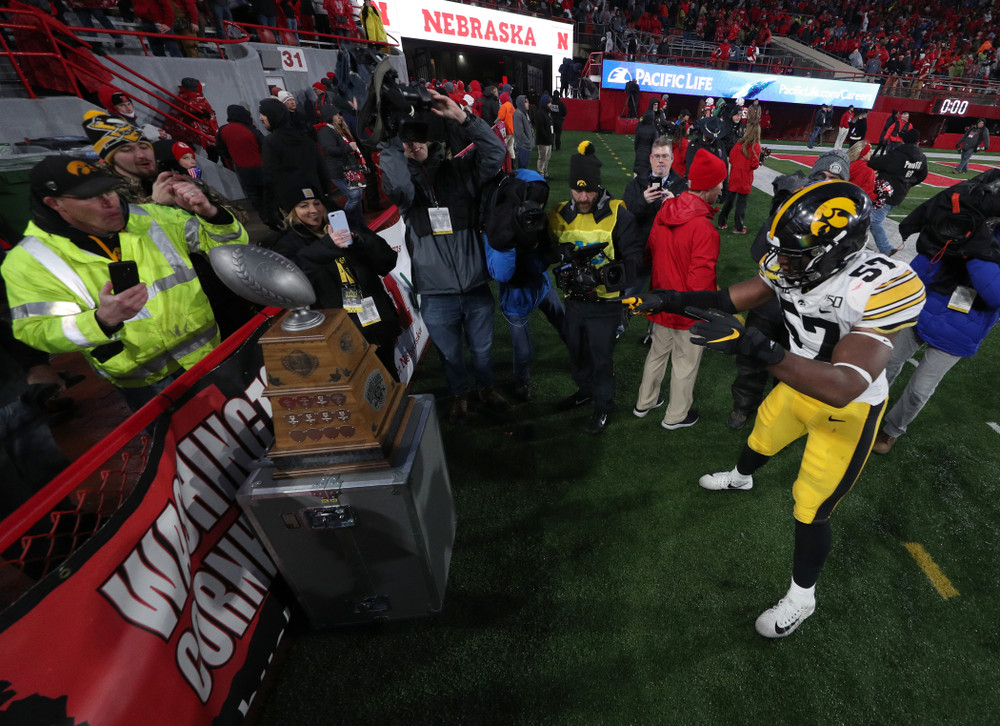 Iowa Hawkeyes defensive end Chauncey Golston (57) carries the Heroes Game trophy off the field following their win against the Nebraska Cornhuskers Friday, November 29, 2019 at Memorial Stadium in Lincoln, Neb. (Brian Ray/hawkeyesports.com)