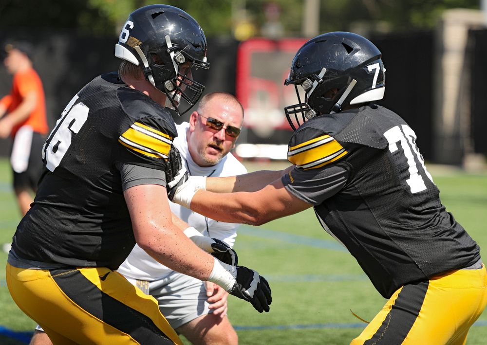 Iowa Hawkeyes offensive lineman Ezra Miller (left) and offensive lineman Kyle Sorensen (right) run a drill as offensive line coach Tim Polasek (center) looks on during Fall Camp Practice #5 at the Hansen Football Performance Center in Iowa City on Tuesday, Aug 6, 2019. (Stephen Mally/hawkeyesports.com)