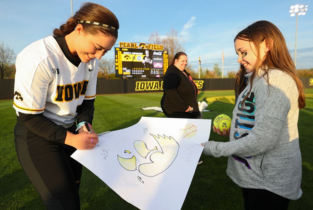 Iowa's Elizabeth DeShields (19) signs a poster for a fan after winning their game against Ohio State at Pearl Field in Iowa City on Friday, May. 3, 2019. (Stephen Mally/hawkeyesports.com)