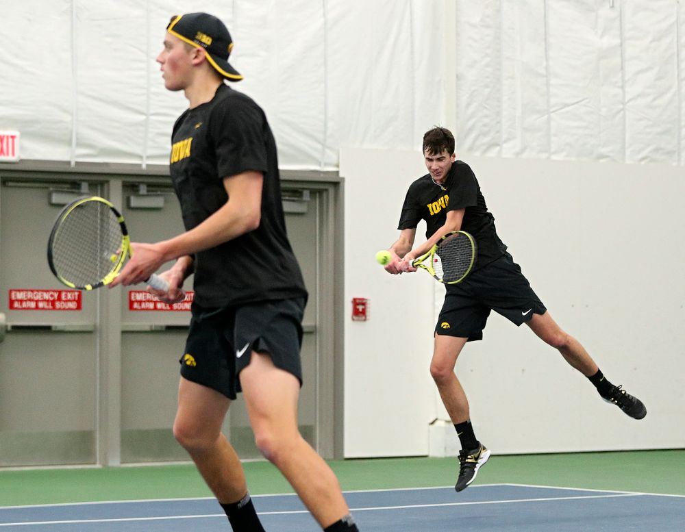 Iowa’s Matt Clegg (right) returns a shot as Joe Tyler (left) looks on during their doubles match at the Hawkeye Tennis and Recreation Complex in Iowa City on Friday, February 14, 2020. (Stephen Mally/hawkeyesports.com)