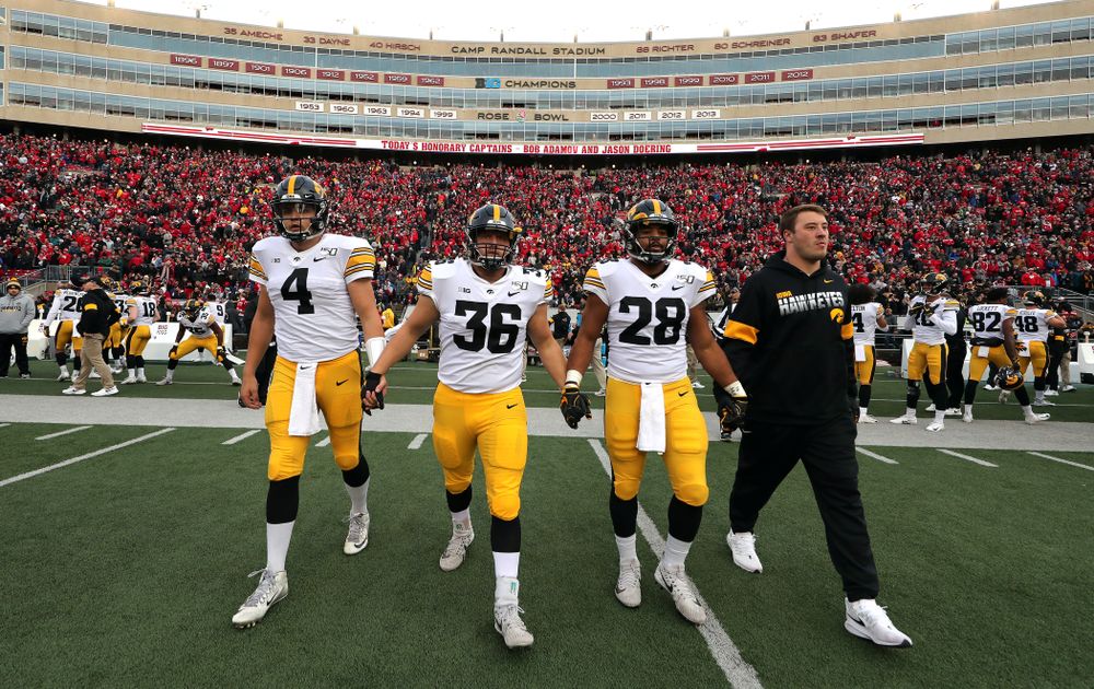 Iowa Hawkeyes captains quarterback Nate Stanley (4), fullback Brady Ross (36), running back Toren Young (28), and linebacker Kristian Welch (34) walk out for the coin toss against the Wisconsin Badgers Saturday, November 9, 2019 at Camp Randall Stadium in Madison, Wisc. (Brian Ray/hawkeyesports.com)