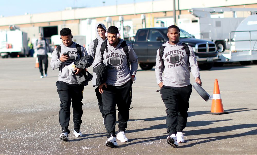 Iowa Hawkeyes running back Ivory Kelly-Martin (21), running back Toren Young (28), and running back Mekhi Sargent (10) board the team plane at the Eastern Iowa Airport Saturday, December 21, 2019 on the way to San Diego, CA for the Holiday Bowl. (Brian Ray/hawkeyesports.com)
