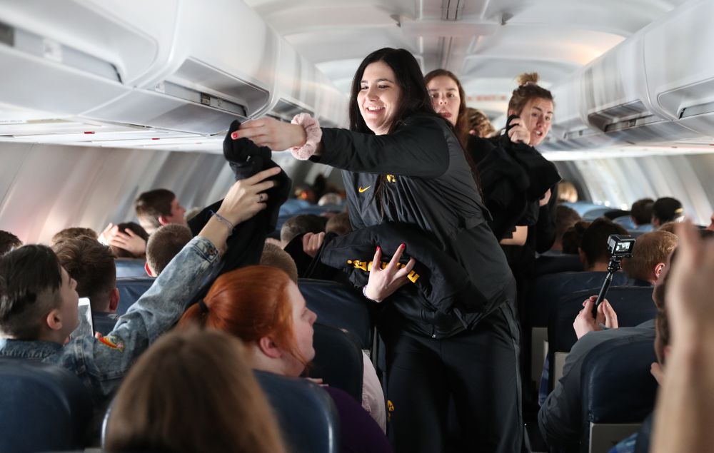 Iowa Hawkeyes forward Megan Gustafson (10) hands out t-shirts to the band and spirit squad on board the team plane to Greensboro, NC for the Regionals of the 2019 NCAA Women's Basketball Championships Thursday, March 28, 2019 at the Eastern Iowa Airport. (Brian Ray/hawkeyesports.com)