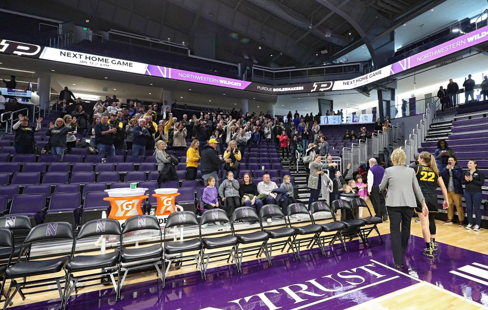 Iowa Hawkeyes fans wave to Iowa Hawkeyes head coach Lisa Bluder and guard Kathleen Doyle (22) as they walk off the court after winning their game at Welsh-Ryan Arena in Evanston, Ill. on Sunday, January 5, 2020. (Stephen Mally/hawkeyesports.com)