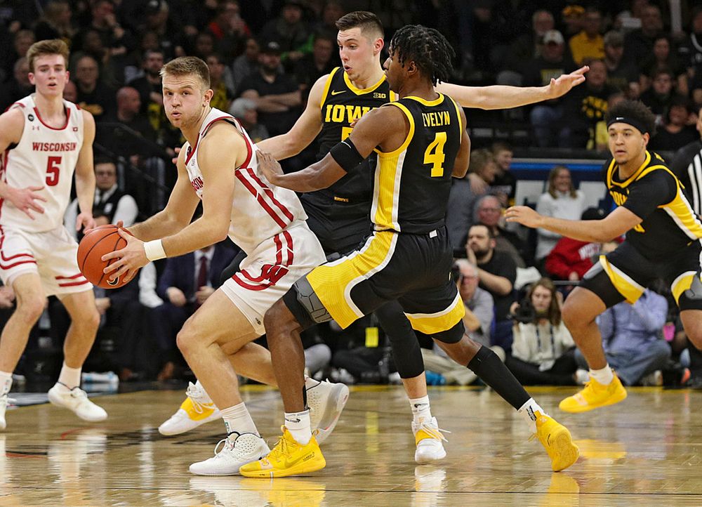 Iowa Hawkeyes guard CJ Fredrick (5) and guard Bakari Evelyn (4) pressure Wisconsin Badgers guard Brad Davison (34) during the first half of their game at Carver-Hawkeye Arena in Iowa City on Monday, January 27, 2020. (Stephen Mally/hawkeyesports.com)