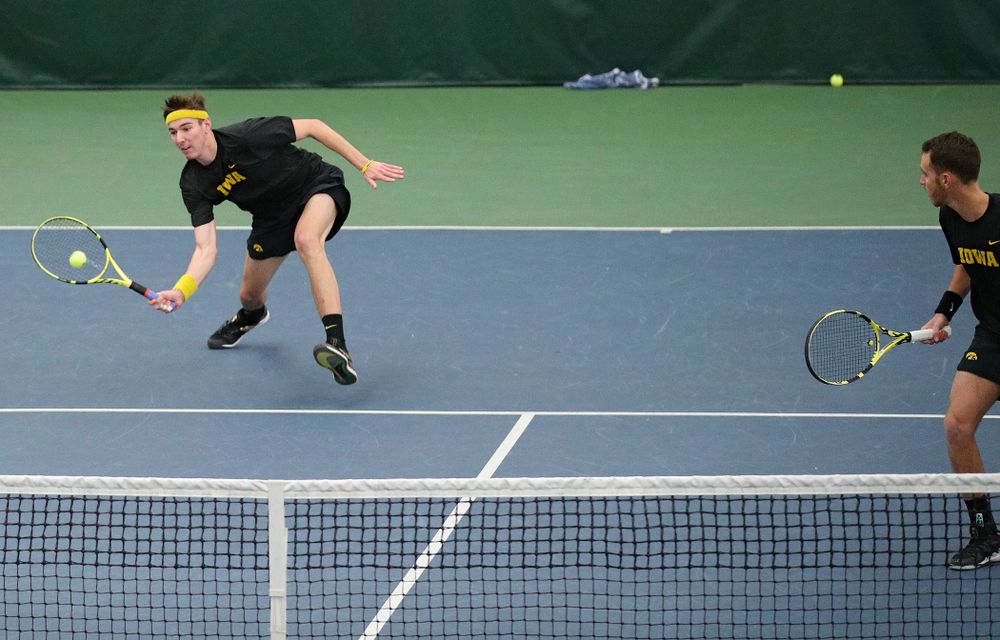 Iowa’s Nikita Snezhko (from left) hits a shot as Kareem Allaf looks on during their doubles match against Marquette at the Hawkeye Tennis and Recreation Complex in Iowa City on Saturday, January 25, 2020. (Stephen Mally/hawkeyesports.com)