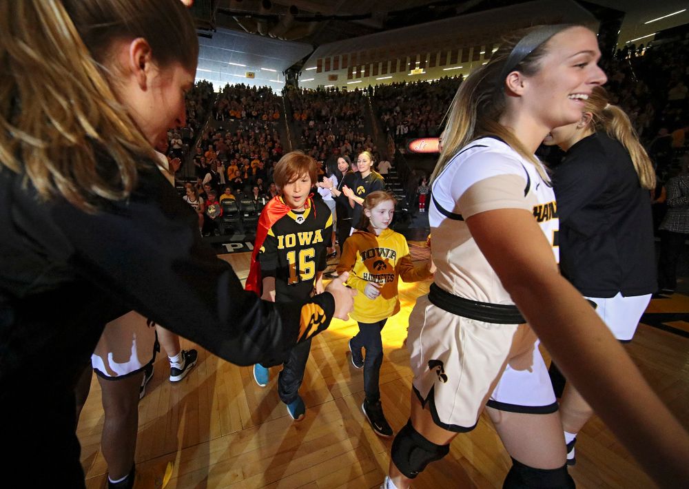 Iowa Hawkeyes guard Makenzie Meyer (3) is introduced with two Go Red for Women Movement Heart Champions before the start of their game at Carver-Hawkeye Arena in Iowa City on Sunday, January 26, 2020. (Stephen Mally/hawkeyesports.com)
