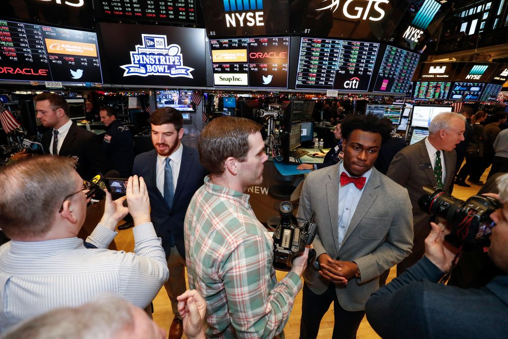Iowa Hawkeyes linebacker Josey Jewell (43), defensive back Joshua Jackson (15), offensive lineman Sean Welsh (79) and head coach Kirk Ferentz ring the opening bell at the New York Stock Exchange Tuesday, December 26, 2017 in New York. (Brian Ray/hawkeyesports.com)