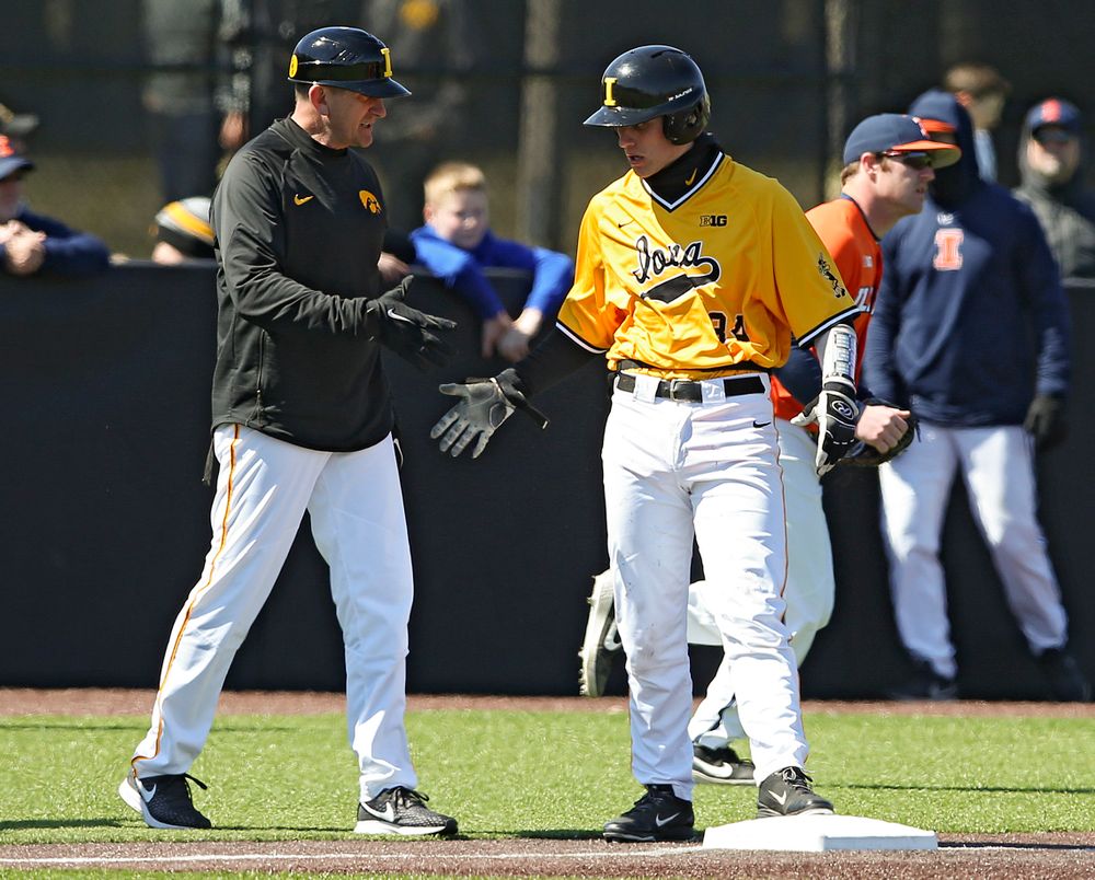 Iowa Hawkeyes head coach Rick Heller shakes hands with catcher Austin Martin (34) after he hit a 2-run triple during the third inning against Illinois at Duane Banks Field in Iowa City on Sunday, Mar. 31, 2019. (Stephen Mally/hawkeyesports.com)