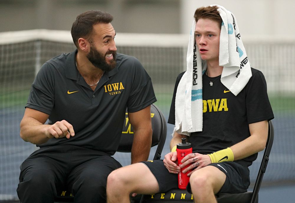 Iowa assistant coach Lloyd Bruce-Burgess (from left) talks with Jason Kerst during his match against Marquette at the Hawkeye Tennis and Recreation Complex in Iowa City on Saturday, January 25, 2020. (Stephen Mally/hawkeyesports.com)