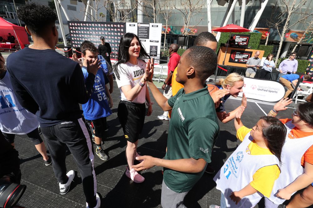 Iowa Hawkeyes forward Megan Gustafson (10) high fives Michigan StateÕs Cassius Winston during a Special Olympics event Friday, April 12, 2019 as part of the ESPN College Basketball Awards in the XBOX Plaza at LA Live.  (Brian Ray/hawkeyesports.com)