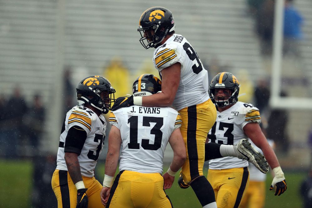 Iowa Hawkeyes linebacker Joe Evans (13) is congratulated by defensive end A.J. Epenesa (94) after recording his first career sack against the Northwestern Wildcats Saturday, October 26, 2019 at Ryan Field in Evanston, Ill. (Brian Ray/hawkeyesports.com)