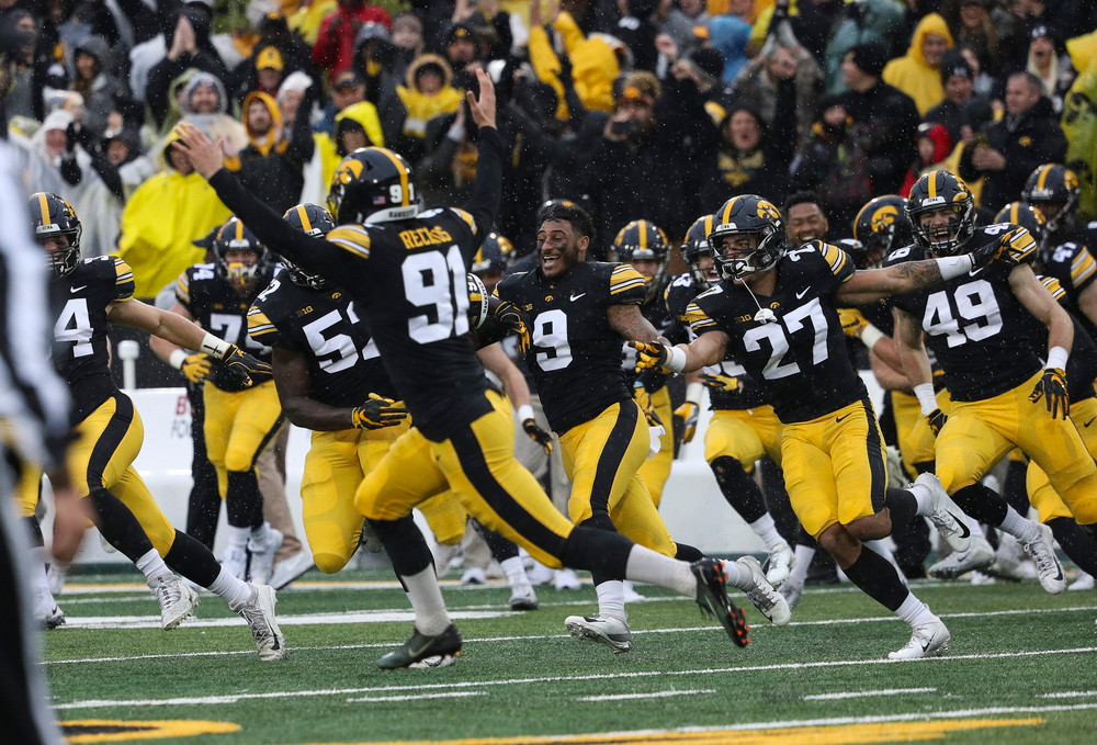 The Iowa Hawkeyes bench rushes the field after a game-winning 41-yard field goal by Iowa Hawkeyes placekicker Miguel Recinos (91) during a game against Nebraska at Kinnick Stadium on November 23, 2018. (Tork Mason/hawkeyesports.com)