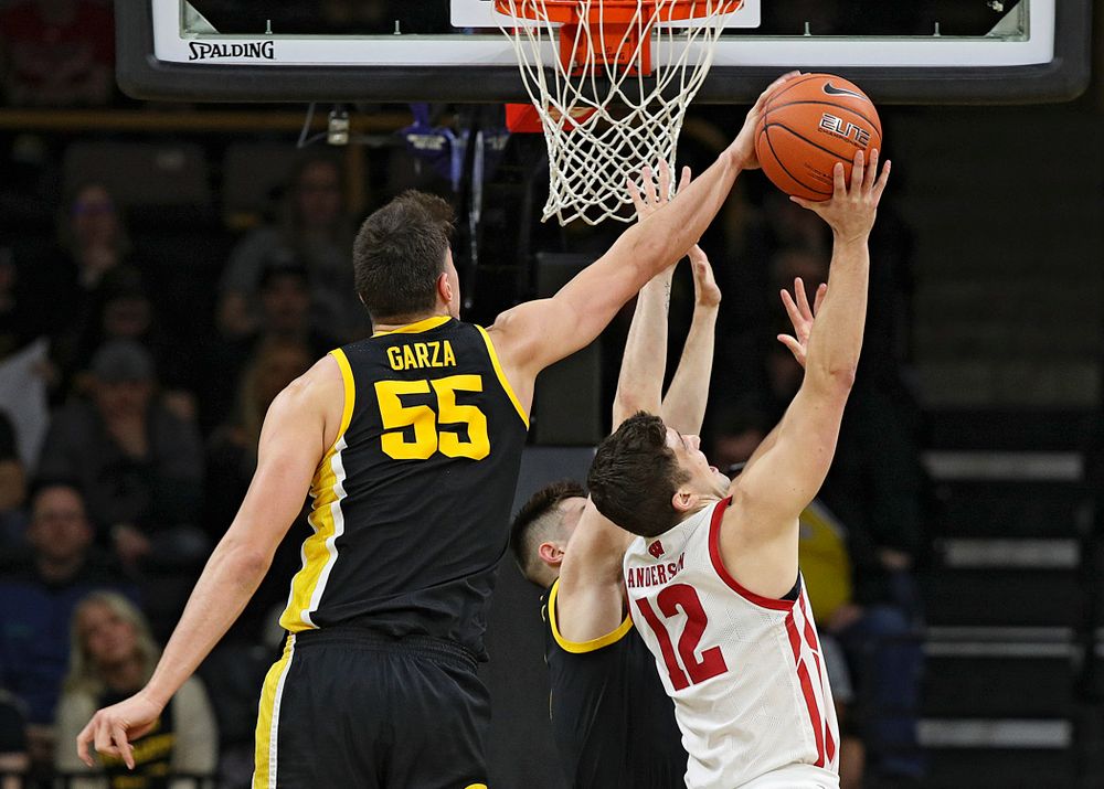 Iowa Hawkeyes center Luka Garza (55) blocks a shot by Wisconsin Badgers guard Trevor Anderson (12) during the first half of their game at Carver-Hawkeye Arena in Iowa City on Monday, January 27, 2020. (Stephen Mally/hawkeyesports.com)
