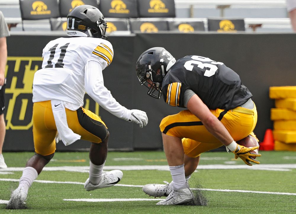 Iowa Hawkeyes tight end Nate Wieting (39) hangs on to a pass behind his back as Iowa Hawkeyes defensive back Michael Ojemudia (11) closes in during Fall Camp Practice No. 8 at Kids Day at Kinnick Stadium in Iowa City on Saturday, Aug 10, 2019. (Stephen Mally/hawkeyesports.com)
