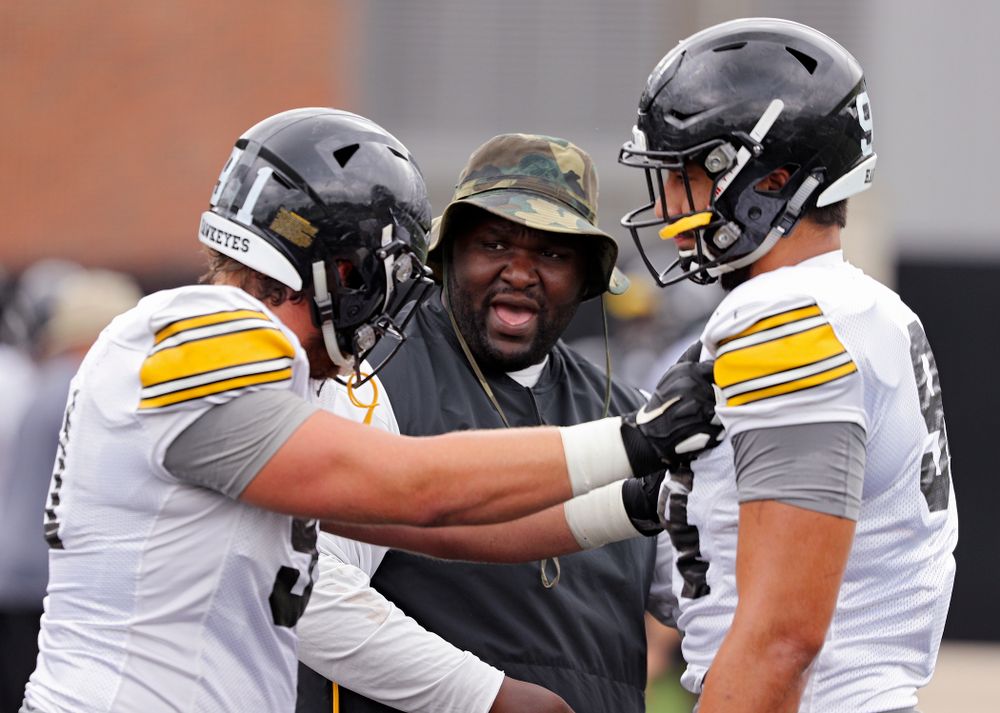 Iowa Hawkeyes defensive line coach Kelvin Bell (center) talks with defensive lineman Brady Reiff (91) and defensive end A.J. Epenesa (94) during Fall Camp Practice No. 15 at the Hansen Football Performance Center in Iowa City on Monday, Aug 19, 2019. (Stephen Mally/hawkeyesports.com)