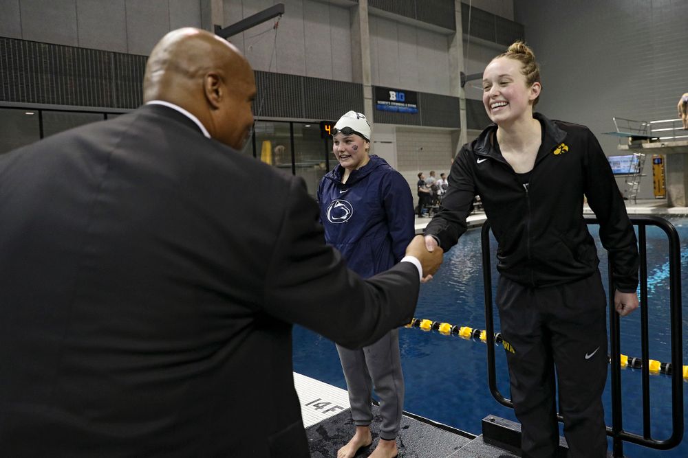 Iowa’s Kelsey Drake (right) shakes hands with Big Ten Commissioner Kevin Warren after swimming the women’s 100 yard butterfly final event during the 2020 Women’s Big Ten Swimming and Diving Championships at the Campus Recreation and Wellness Center in Iowa City on Friday, February 21, 2020. (Stephen Mally/hawkeyesports.com)
