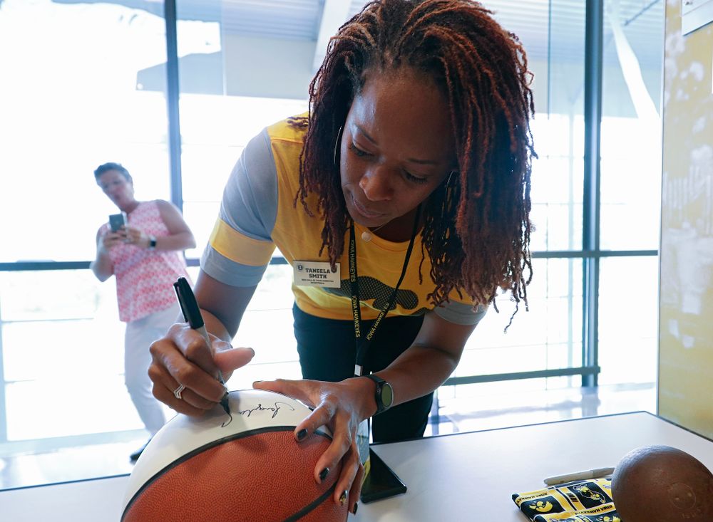 2019 University of Iowa Athletics Hall of Fame inductee Tangela Smith signs a basketball at the University of Iowa Athletics Hall of Fame in Iowa City on Friday, Aug 30, 2019. (Stephen Mally/hawkeyesports.com)