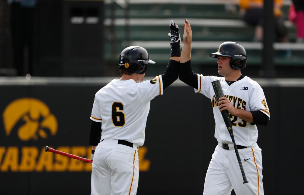 Iowa Hawkeyes infielder Kyle Crowl (23) high fives outfielder Justin Jenkins (6) after scoring against the Missouri Tigers Tuesday, May 1, 2018 at Duane Banks Field. (Brian Ray/hawkeyesports.com)