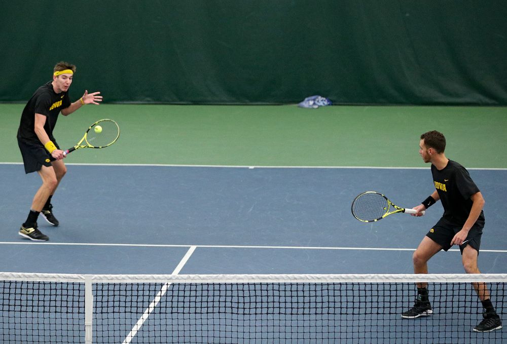 Iowa’s Nikita Snezhko (from left) hits a shot as Kareem Allaf looks on during their doubles match against Marquette at the Hawkeye Tennis and Recreation Complex in Iowa City on Saturday, January 25, 2020. (Stephen Mally/hawkeyesports.com)
