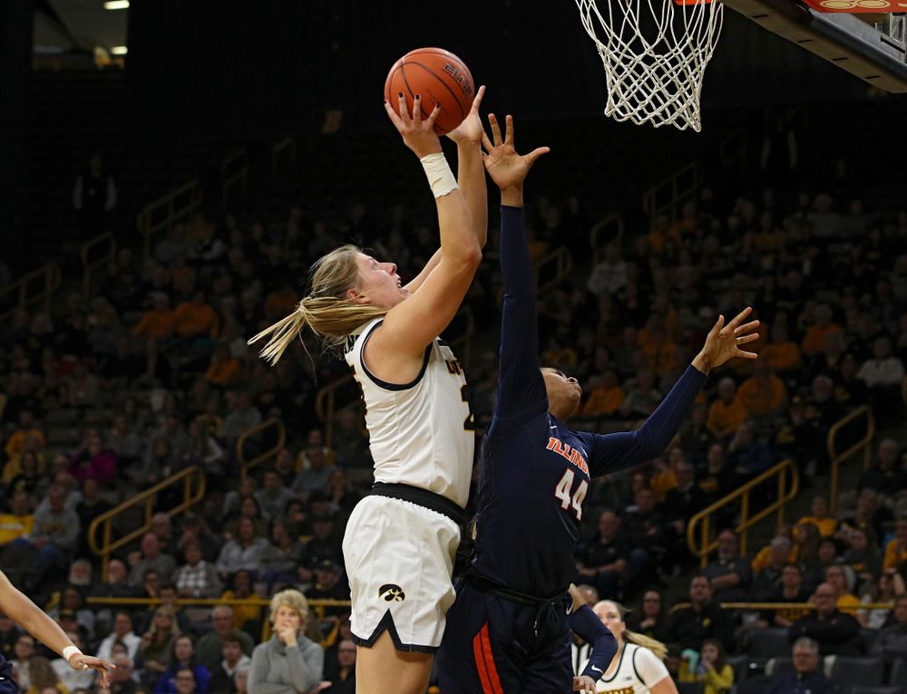 Iowa Hawkeyes forward Monika Czinano (25) scores a basket over the hand of Illinois Fighting Illini forward Kennedi Myles (44) during the third quarter of their game at Carver-Hawkeye Arena in Iowa City on Tuesday, December 31, 2019. (Stephen Mally/hawkeyesports.com)