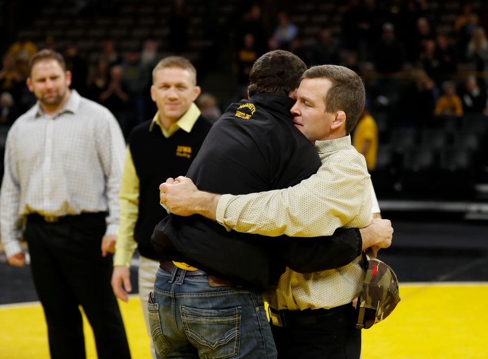 Iowa senior Logan McQuillen hugs associate head coach Terry Brands following their meet against Northwestern  