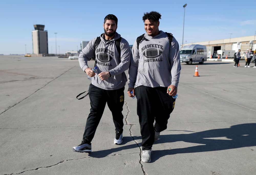 Iowa Hawkeyes defensive end A.J. Epenesa (94) and offensive lineman Tristan Wirfs (74) board the team plane at the Eastern Iowa Airport Saturday, December 21, 2019 on the way to San Diego, CA for the Holiday Bowl. (Brian Ray/hawkeyesports.com)