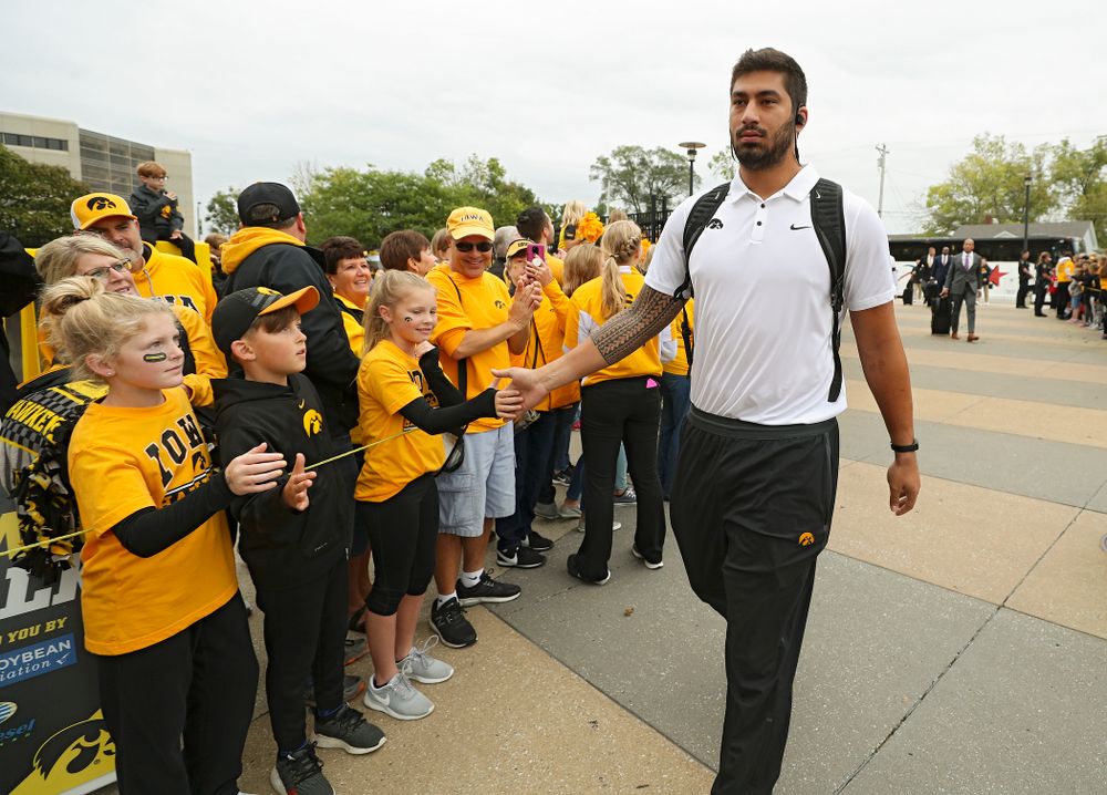 Iowa Hawkeyes defensive end A.J. Epenesa (94) gives high-fives to kids as he arrives with his team before their game at Kinnick Stadium in Iowa City on Saturday, Sep 28, 2019. (Stephen Mally/hawkeyesports.com)