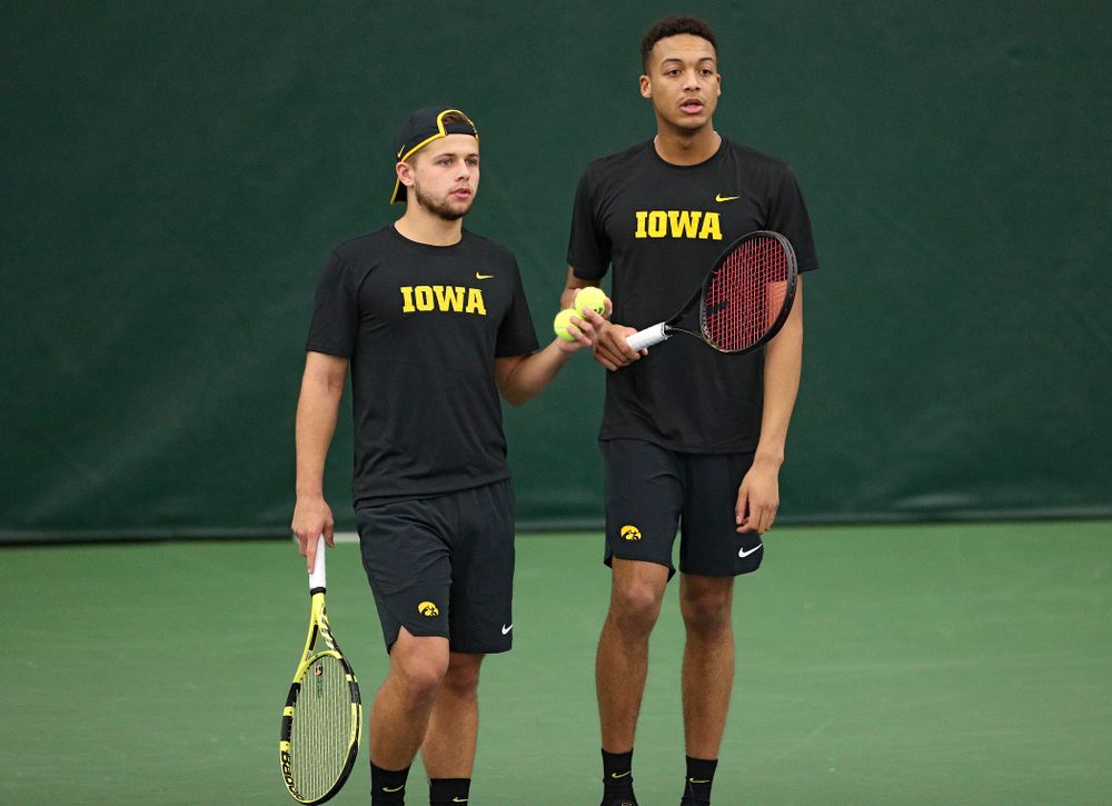 Iowa’s Will Davies (from left) and Oliver Okonkwo talk during their doubles match against Marquette at the Hawkeye Tennis and Recreation Complex in Iowa City on Saturday, January 25, 2020. (Stephen Mally/hawkeyesports.com)