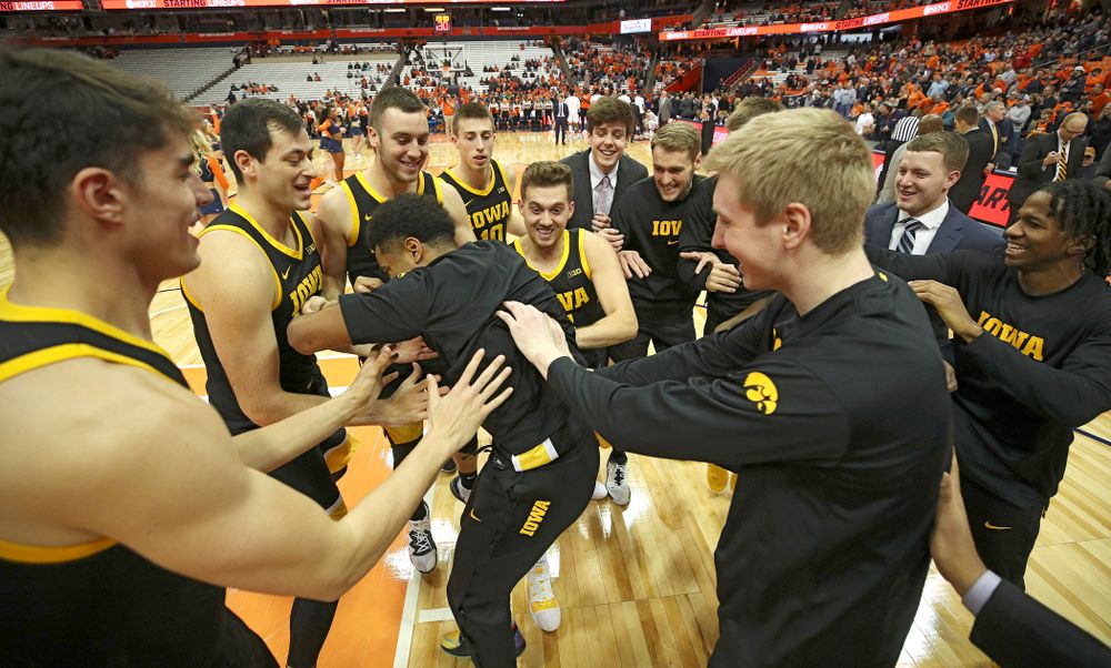 Iowa Hawkeyes guard Jordan Bohannon (3), forward Riley Till (20), and center Luka Garza (55) celebrate after winning their ACC/Big Ten Challenge game at the Carrier Dome in Syracuse, N.Y. on Tuesday, Dec 3, 2019. (Stephen Mally/hawkeyesports.com)