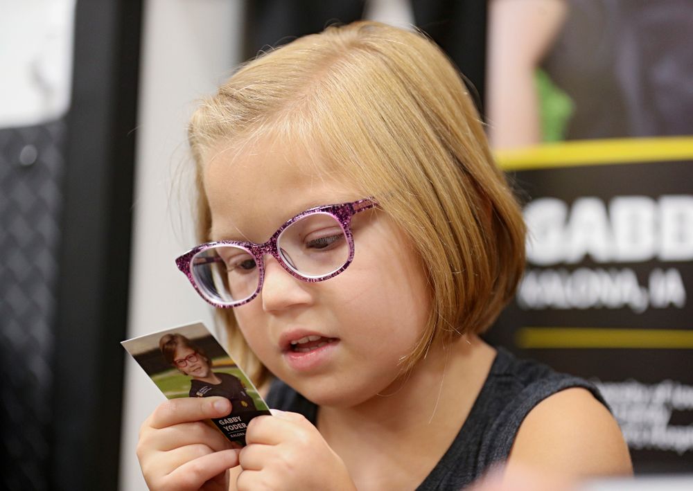 Kid Captain Gabby Yoder reads the back of her trading card during Kids Day at Kinnick Stadium in Iowa City on Saturday, Aug 10, 2019. (Stephen Mally/hawkeyesports.com)