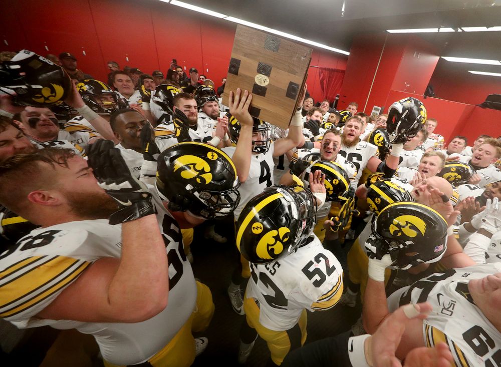 Iowa Hawkeyes quarterback Nate Stanley (4) hoists the Heroes Game trophy as they celebrate their win against the Nebraska Cornhuskers Friday, November 29, 2019 at Memorial Stadium in Lincoln, Neb. (Brian Ray/hawkeyesports.com)