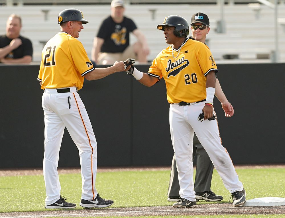 Iowa Hawkeyes head coach Rick Heller greets first baseman Izaya Fullard (20) on third base during the third inning of their game against Northern Illinois at Duane Banks Field in Iowa City on Tuesday, Apr. 16, 2019. (Stephen Mally/hawkeyesports.com)